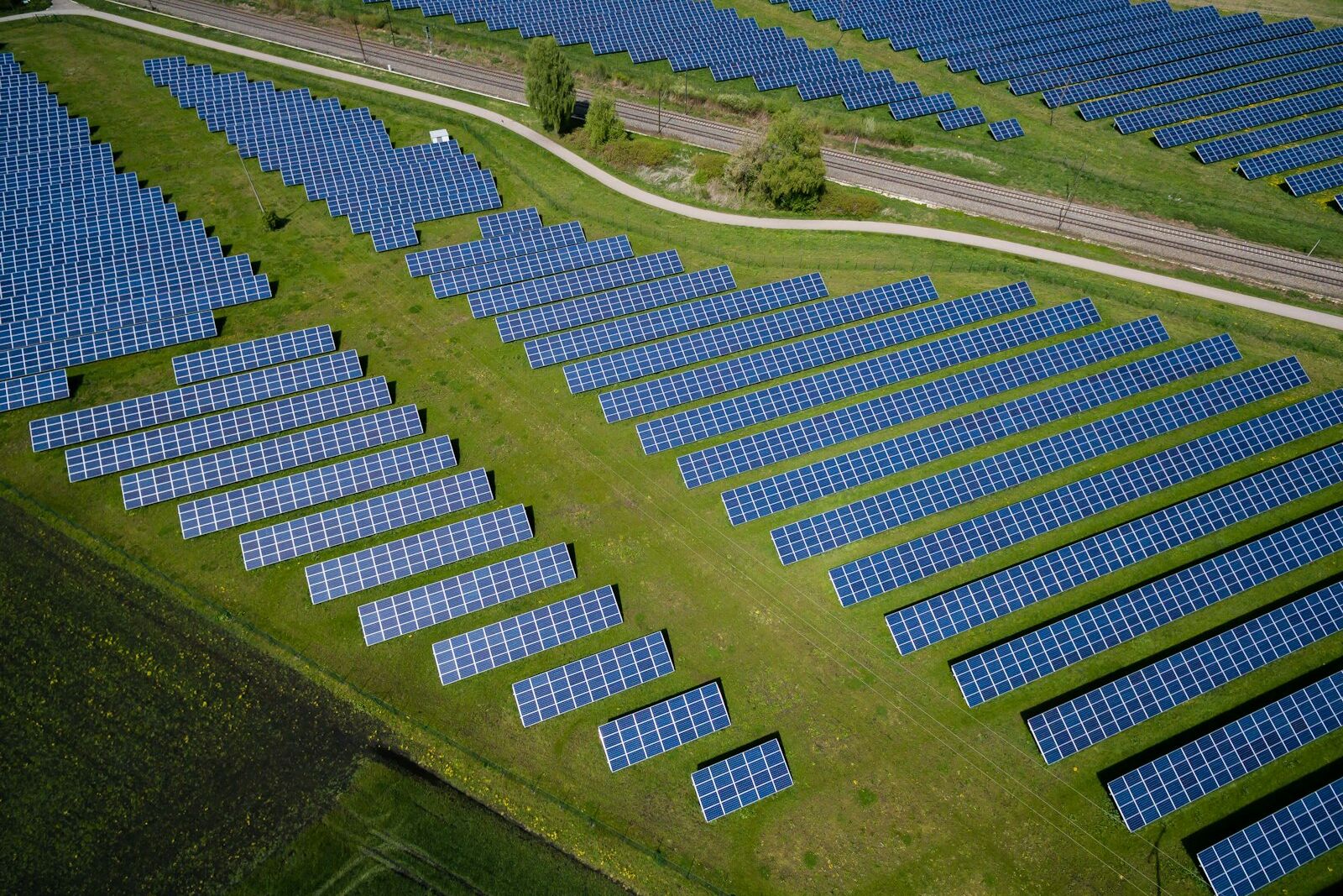 Aerial view of solar farm rows with grass between panels